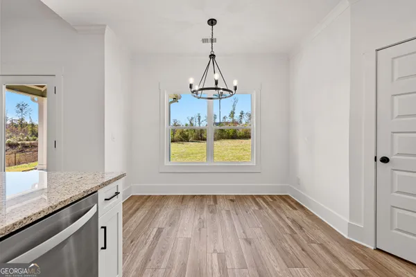 a view of a room with wooden floor and a window
