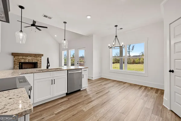 a kitchen with a sink chandelier and wooden floor