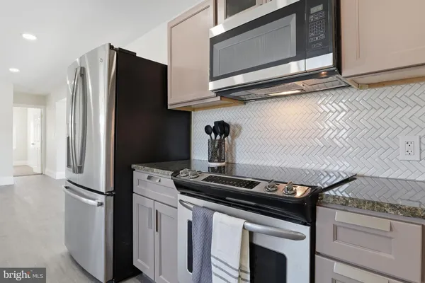 a kitchen with stainless steel appliances granite countertop a stove microwave and refrigerator