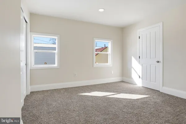 an empty room with windows and closet