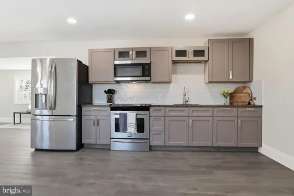 a kitchen with stainless steel appliances a refrigerator sink and microwave