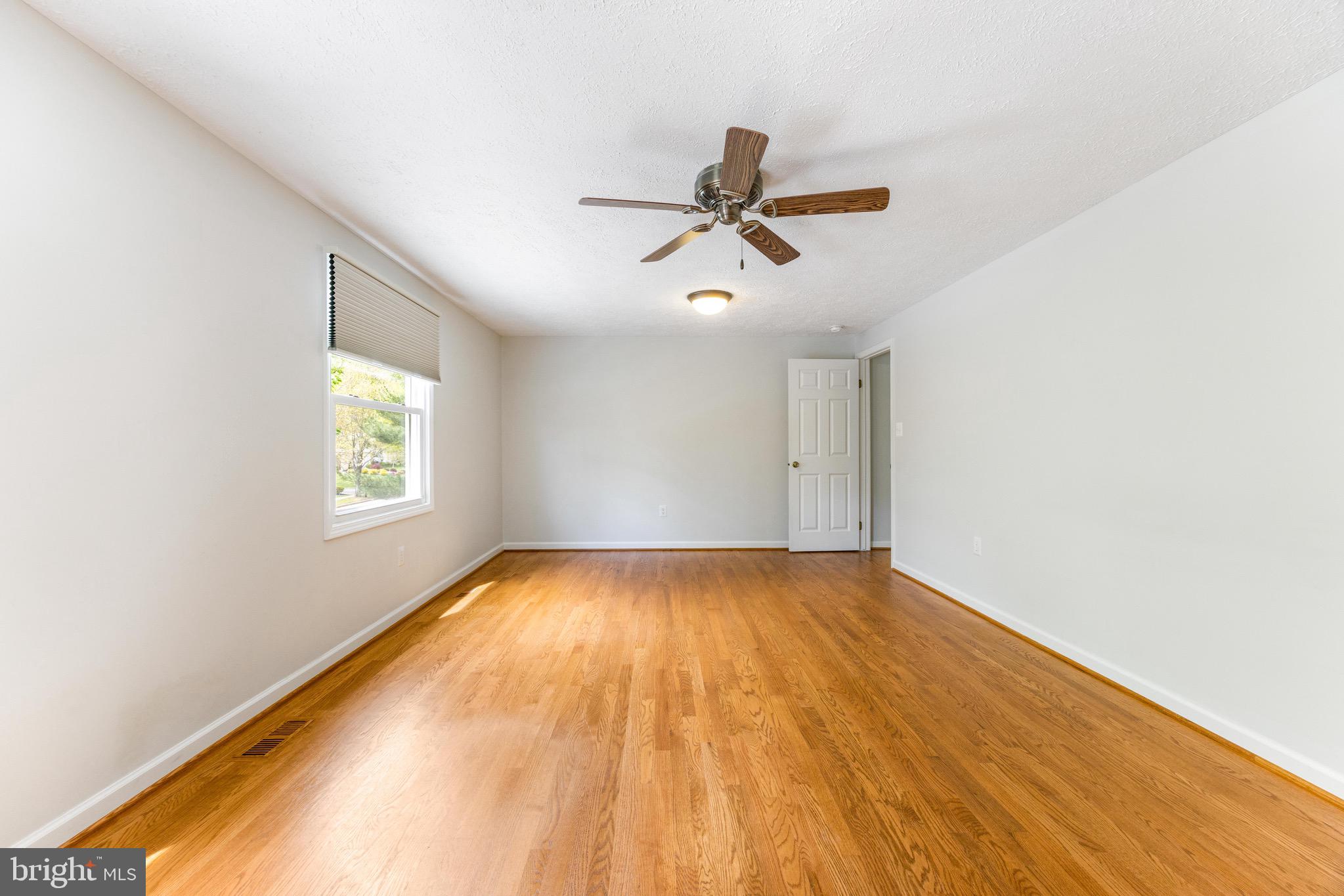 8735 Doves Fly Way Laurel, MD 20723 - Photo 35 of 64 a view of empty room with wooden floor and fan