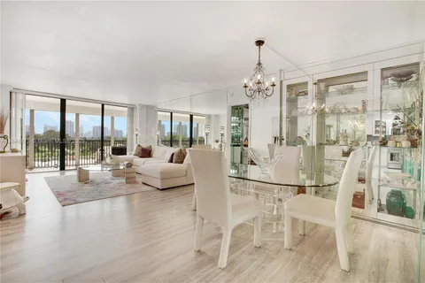 a living room with couches a coffee table and a large window with outer view