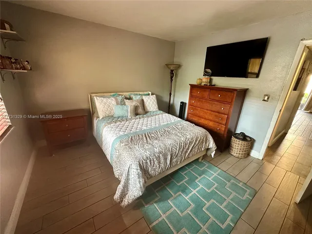 a bedroom with a bed and flat screen tv