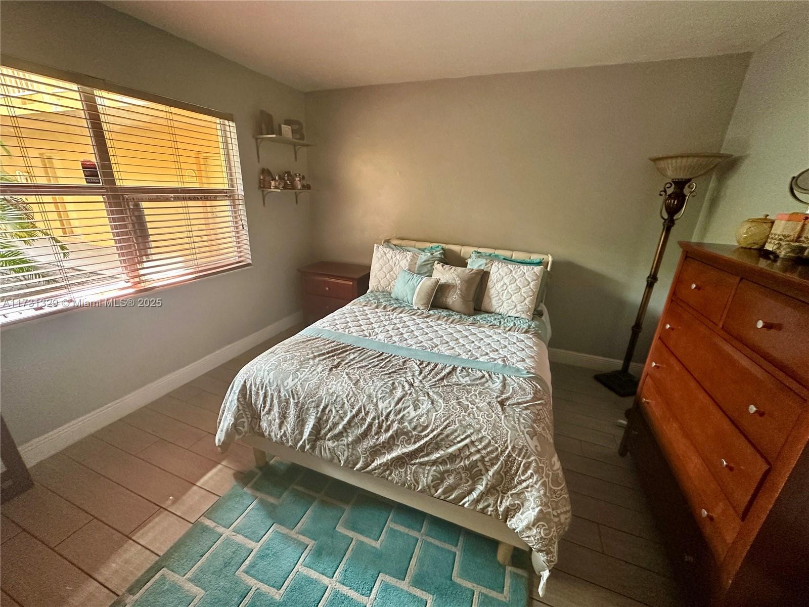 17911 Northwest 68th Avenue, Unit M106 Hialeah, FL 33015 - Photo 15 of 43 a bedroom with a bed and a window