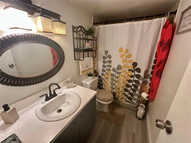 a bathroom with a sink and mirror with toilet