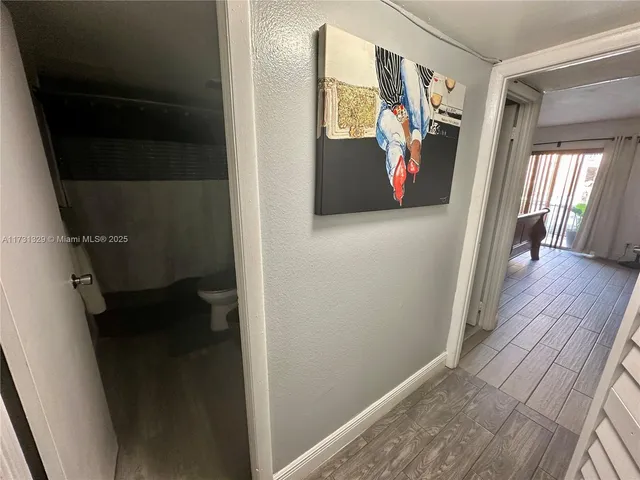 a view of a hallway with wooden floor and door