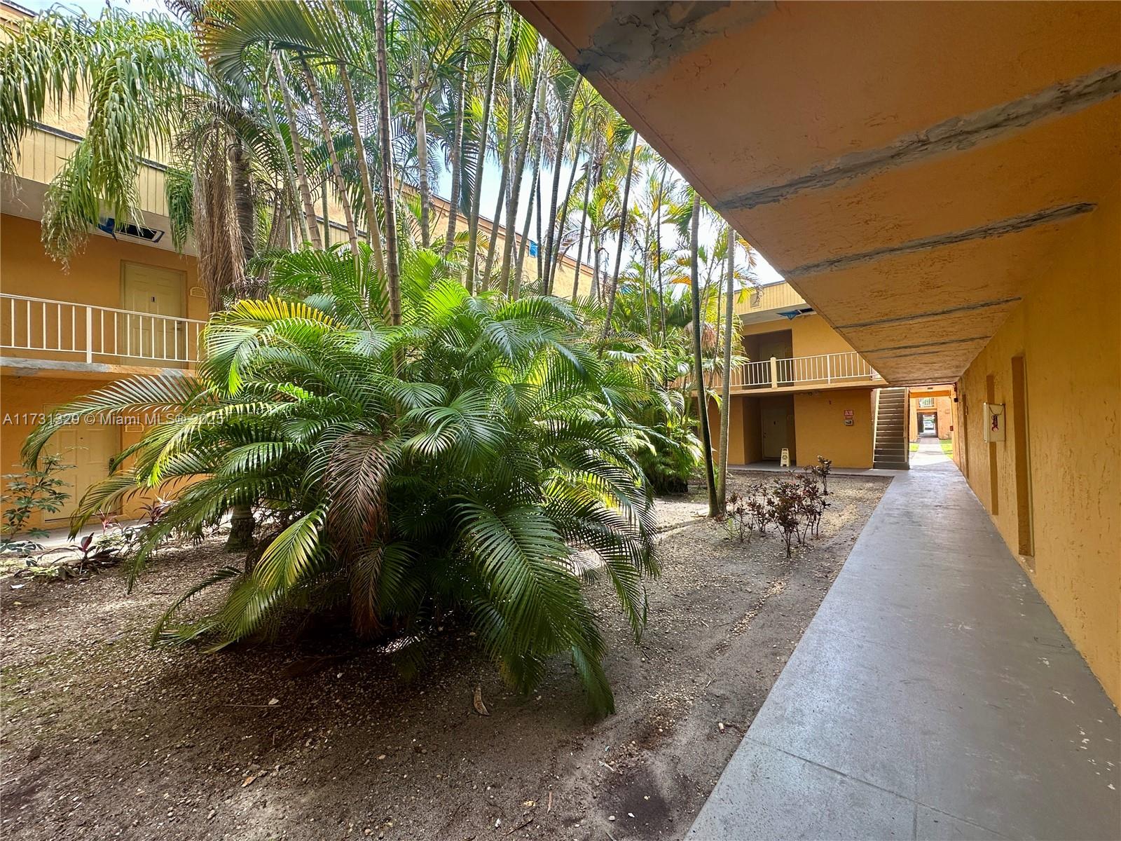 17911 Northwest 68th Avenue, Unit M106 Hialeah, FL 33015 - Photo 29 of 43 a view of a porch with chairs and potted plants