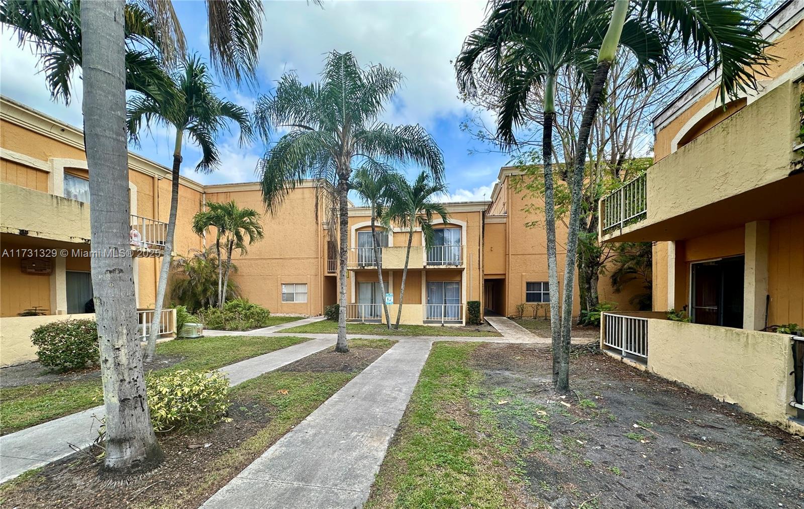 17911 Northwest 68th Avenue, Unit M106 Hialeah, FL 33015 - Photo 30 of 43 a front view of multiple houses with yard