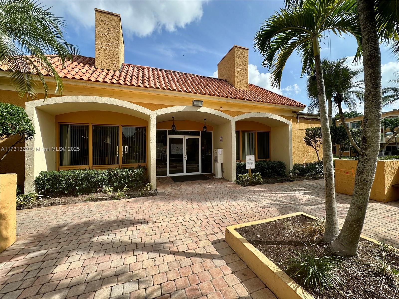 17911 Northwest 68th Avenue, Unit M106 Hialeah, FL 33015 - Photo 3 of 43 a front view of a house with garden