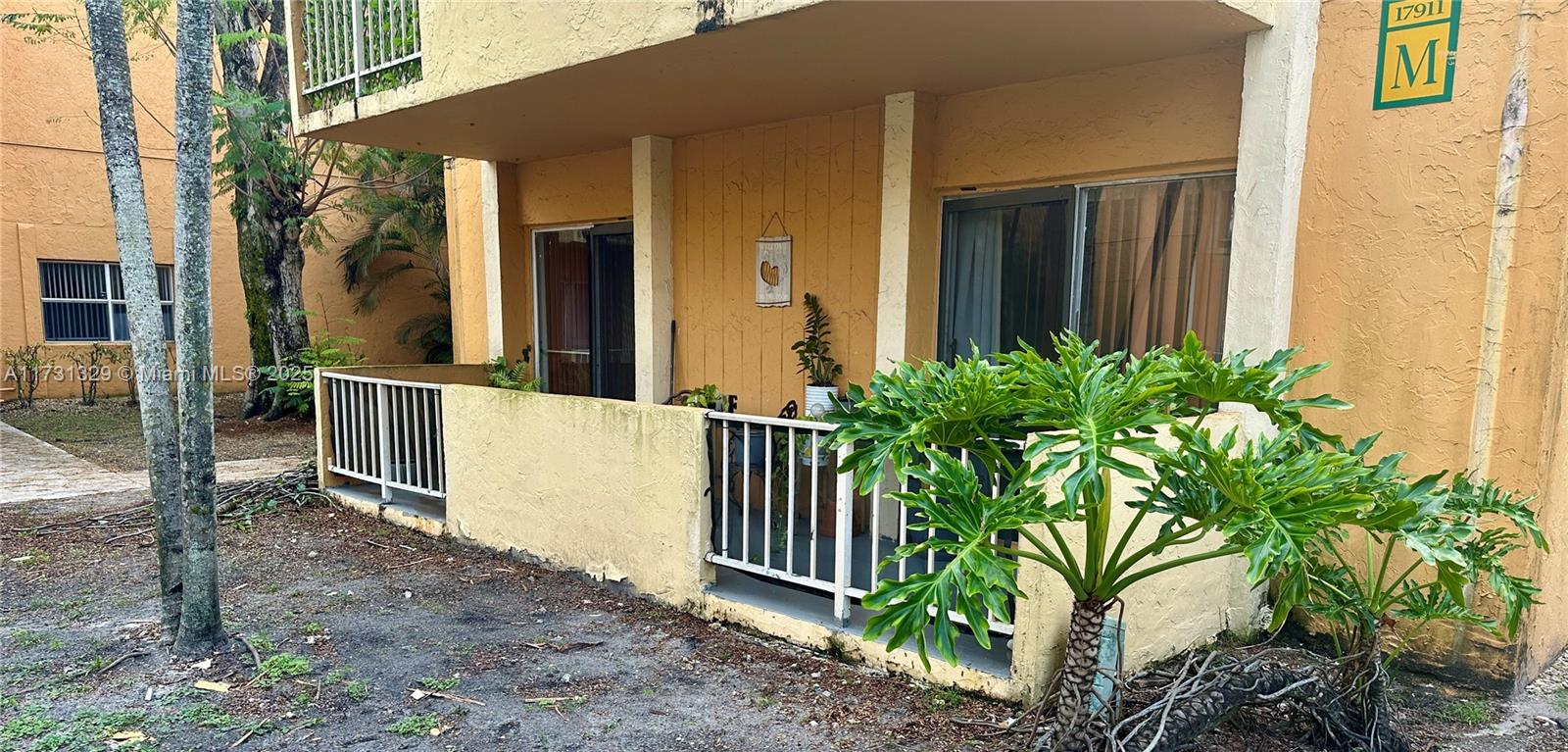 17911 Northwest 68th Avenue, Unit M106 Hialeah, FL 33015 - Photo 31 of 43 a view of a house with a small yard and floor to ceiling window