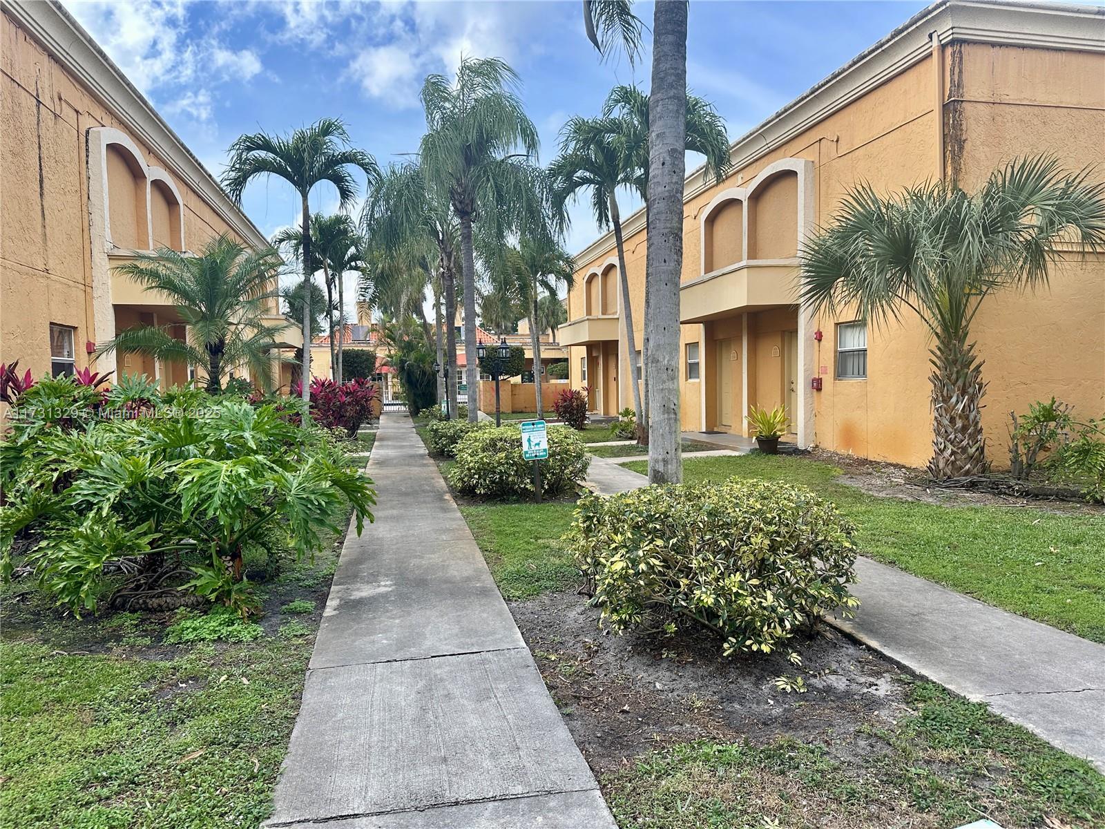 17911 Northwest 68th Avenue, Unit M106 Hialeah, FL 33015 - Photo 33 of 43 a view of a pathway with a house in the background