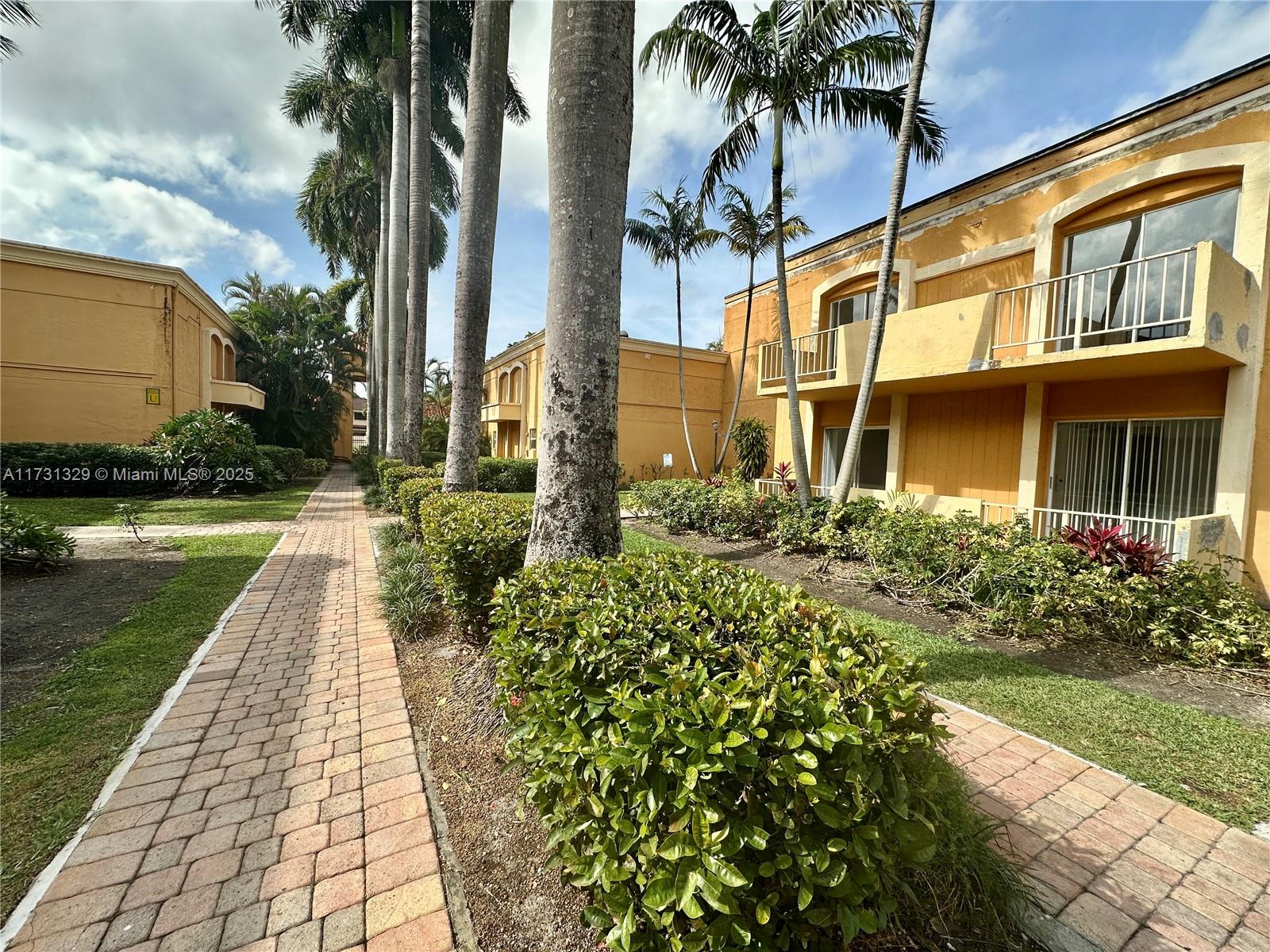 17911 Northwest 68th Avenue, Unit M106 Hialeah, FL 33015 - Photo 41 of 43 a front view of a house with garden
