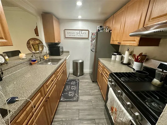 a kitchen with sink a stove and cabinets