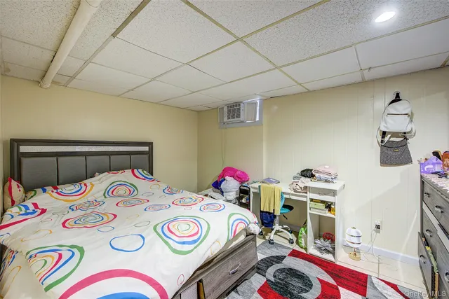 a bedroom with a bed a dresser and a table