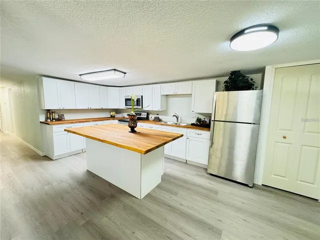 a kitchen with stainless steel appliances a refrigerator a sink and a stove