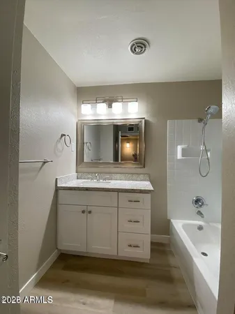 a bathroom with a tub sink and mirror