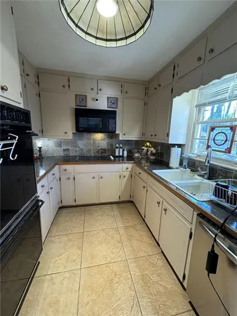 a kitchen with a sink a stove and cabinets