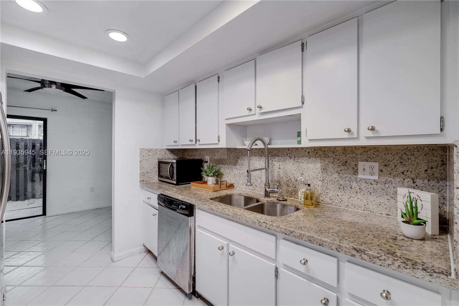 11483 Southwest 109th Road, Unit 2E Miami, FL 33176 - Photo 6 of 45 a kitchen with granite countertop white cabinets and white appliances