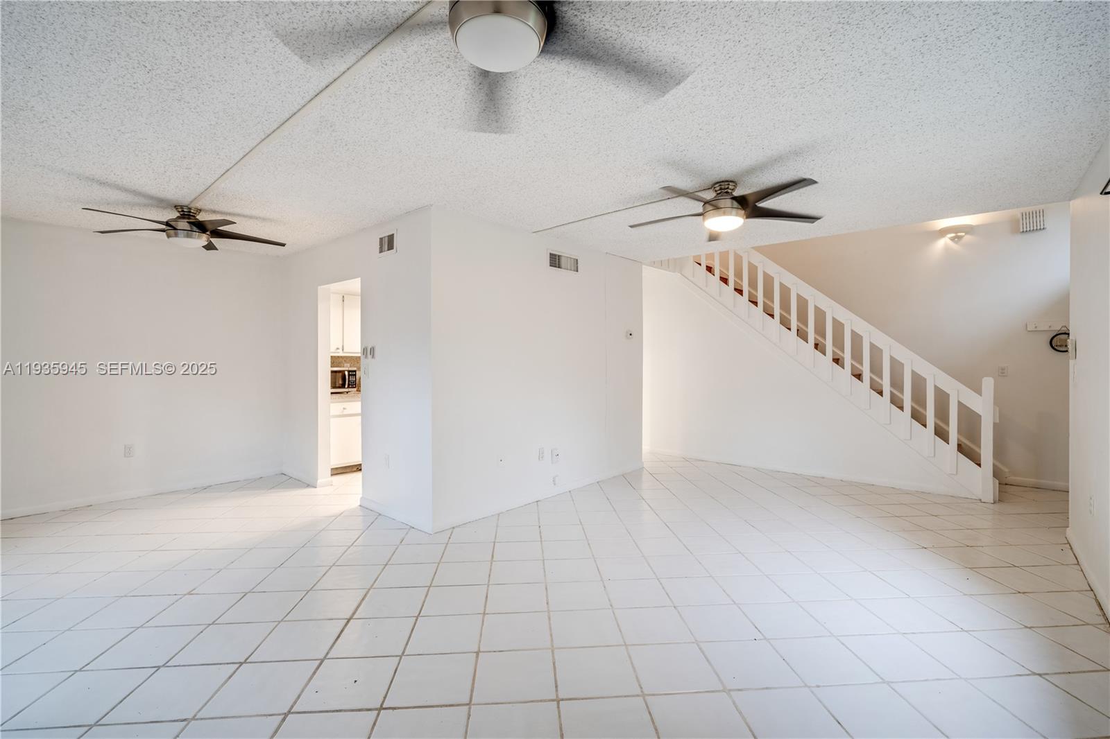 11483 Southwest 109th Road, Unit 2E Miami, FL 33176 - Photo 9 of 45 a view of an empty room and a ceiling fan