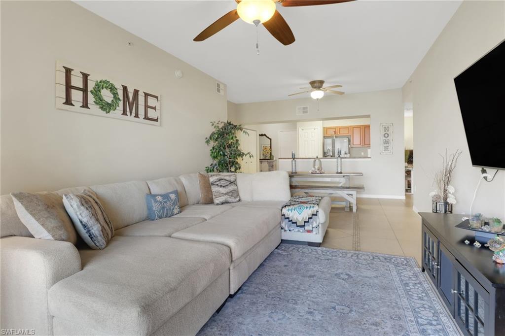 20221 Estero Gardens Circle, Unit 104 Estero, FL 33928 - Photo 12 of 43 a living room with furniture and a flat screen tv