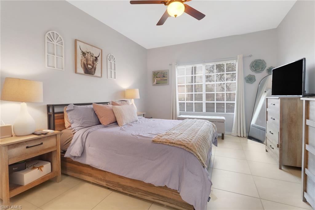 20221 Estero Gardens Circle, Unit 104 Estero, FL 33928 - Photo 14 of 43 a bedroom with bed and a flat tv screen
