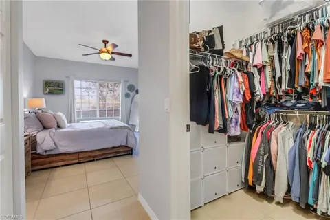 a view of walk in closet with clothes and shoes