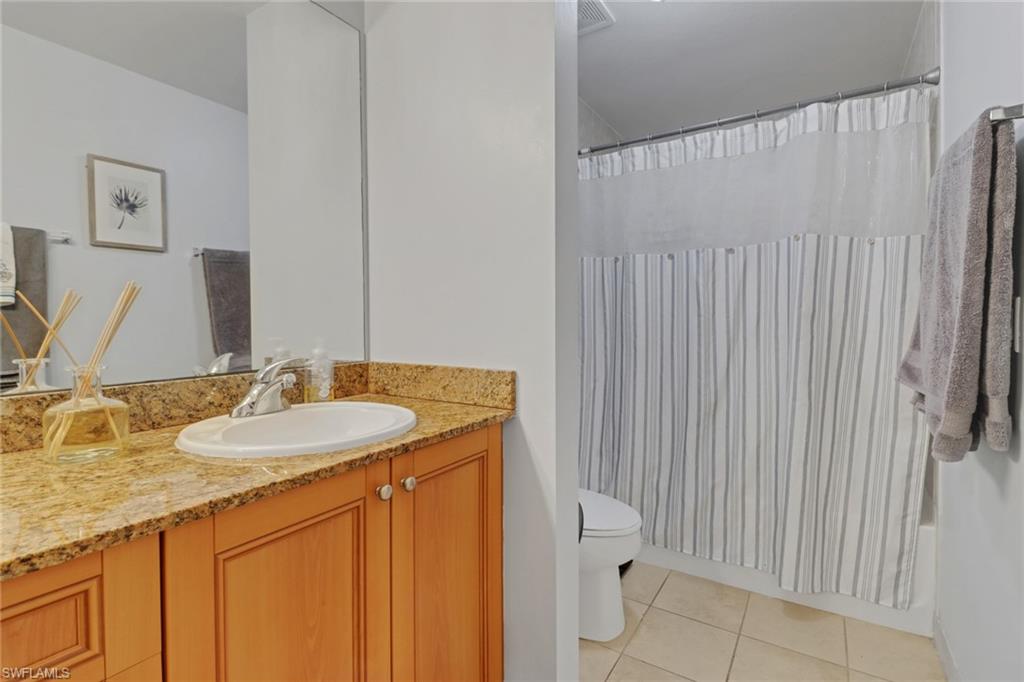 20221 Estero Gardens Circle, Unit 104 Estero, FL 33928 - Photo 16 of 43 a bathroom with a granite countertop sink and a mirror