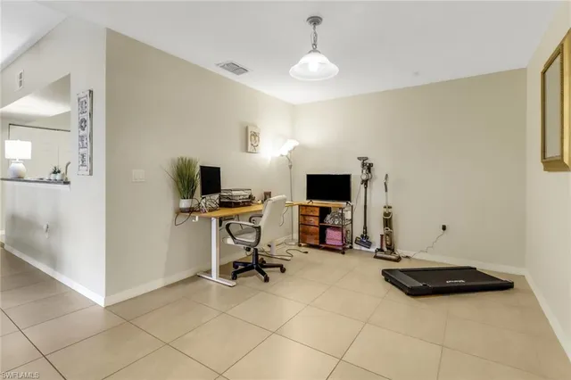 a view of a workspace with furniture and a window