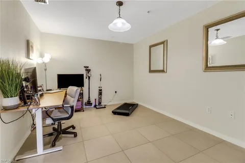 a work room with furniture a potted plant and a lamp