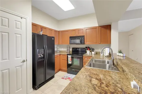 a kitchen with stainless steel appliances granite countertop a refrigerator stove and sink