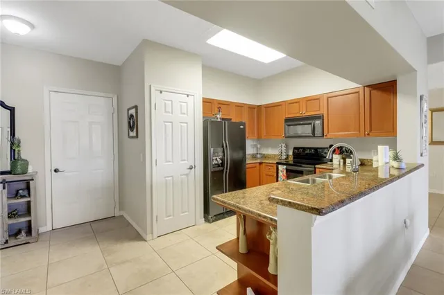 a kitchen with stainless steel appliances granite countertop a refrigerator stove and sink