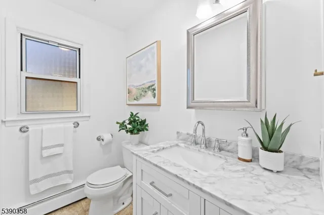 a bathroom with a granite countertop sink toilet and mirror
