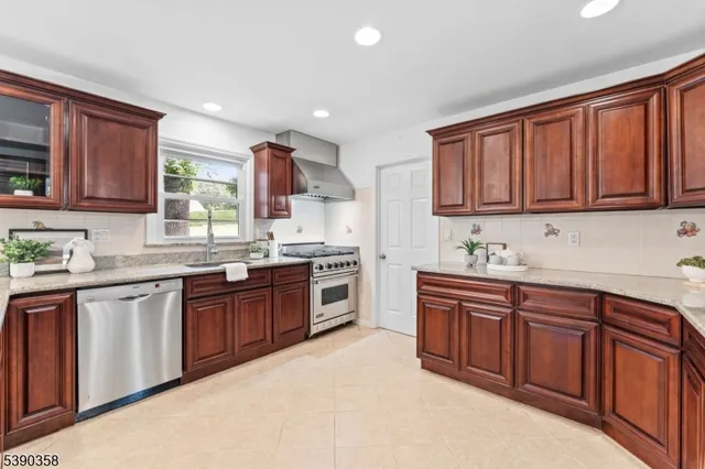 a kitchen with stainless steel appliances granite countertop a sink dishwasher stove and cabinets