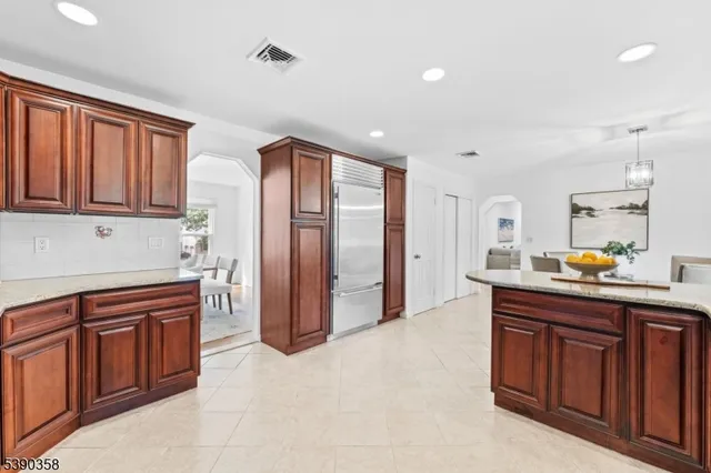a kitchen with stainless steel appliances granite countertop a refrigerator and wooden cabinets