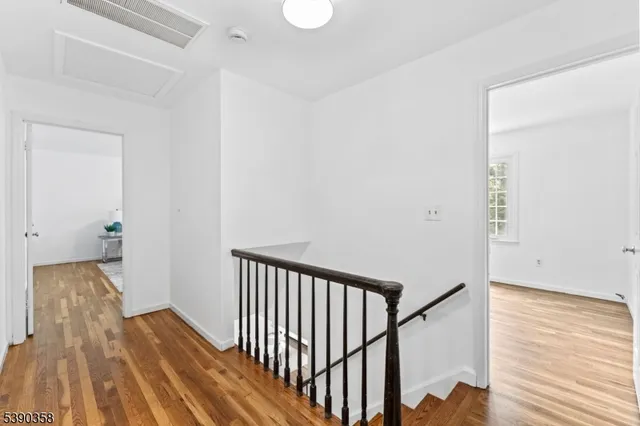 a view of a hallway with wooden floor and staircase
