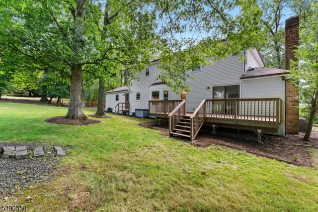 a view of a house with backyard and a tree