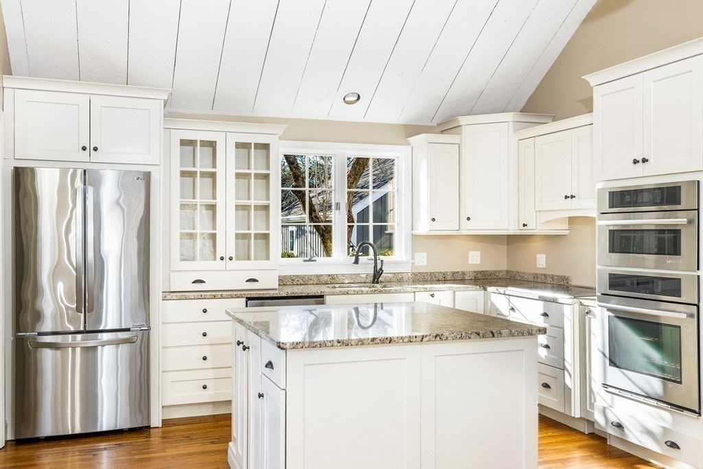 70 Thistle Patch Way, Unit 70 Hingham, MA 02043 - Photo 14 of 41 a kitchen with granite countertop a refrigerator stove and white cabinets