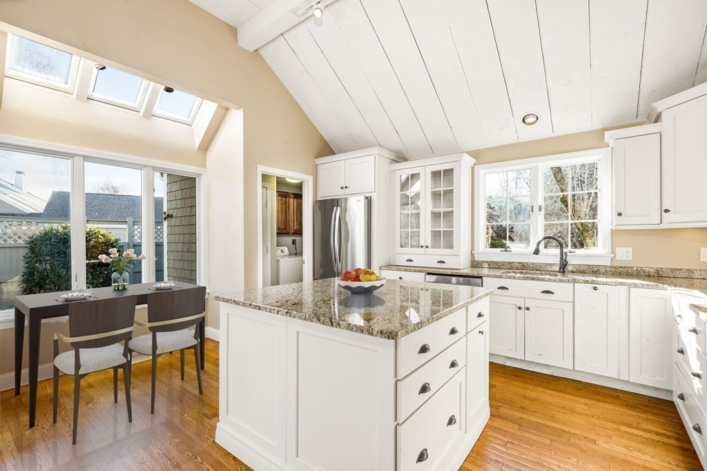 70 Thistle Patch Way, Unit 70 Hingham, MA 02043 - Photo 16 of 41 a large white kitchen with granite countertop a stove a sink a dining table and chairs