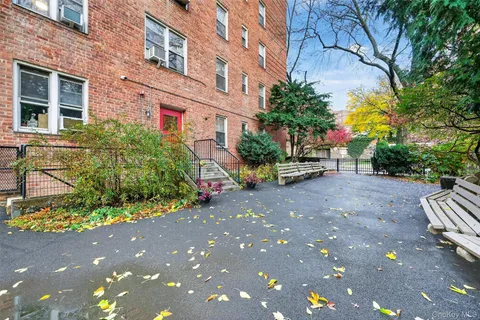 a view of a street with potted plants and a building
