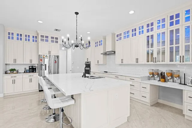a kitchen with a dining table chairs and a chandelier