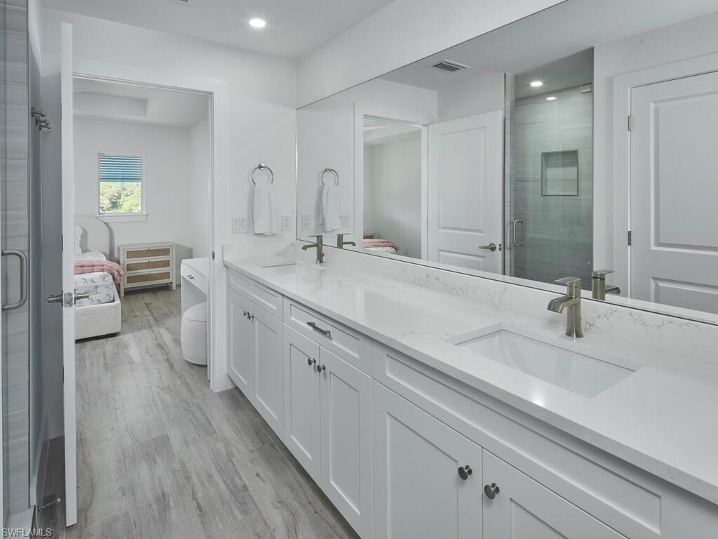 1448 10th Street North Naples, FL 34102 - Photo 11 of 18 a spacious bathroom with a double vanity sink and a mirror