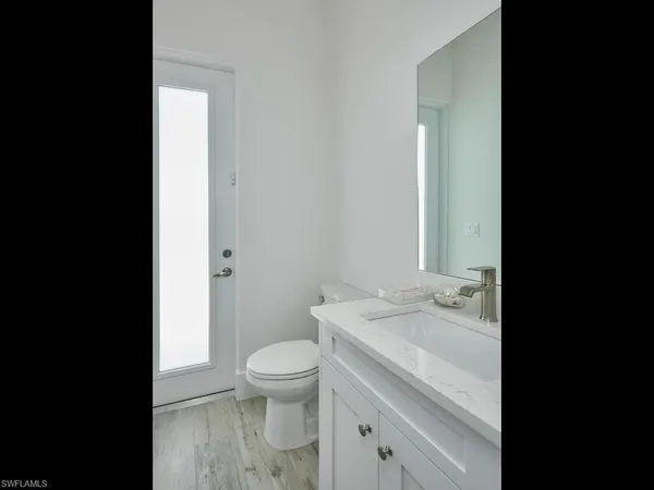 a bathroom with a granite countertop toilet a sink and a mirror
