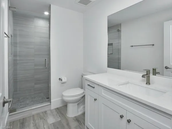 a bathroom with a sink a toilet and shower