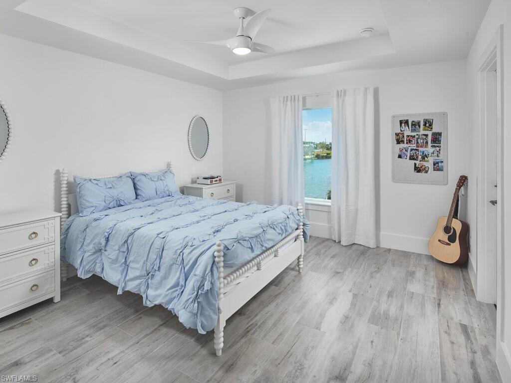 1448 10th Street North Naples, FL 34102 - Photo 10 of 18 a bedroom with a bed and a chandelier