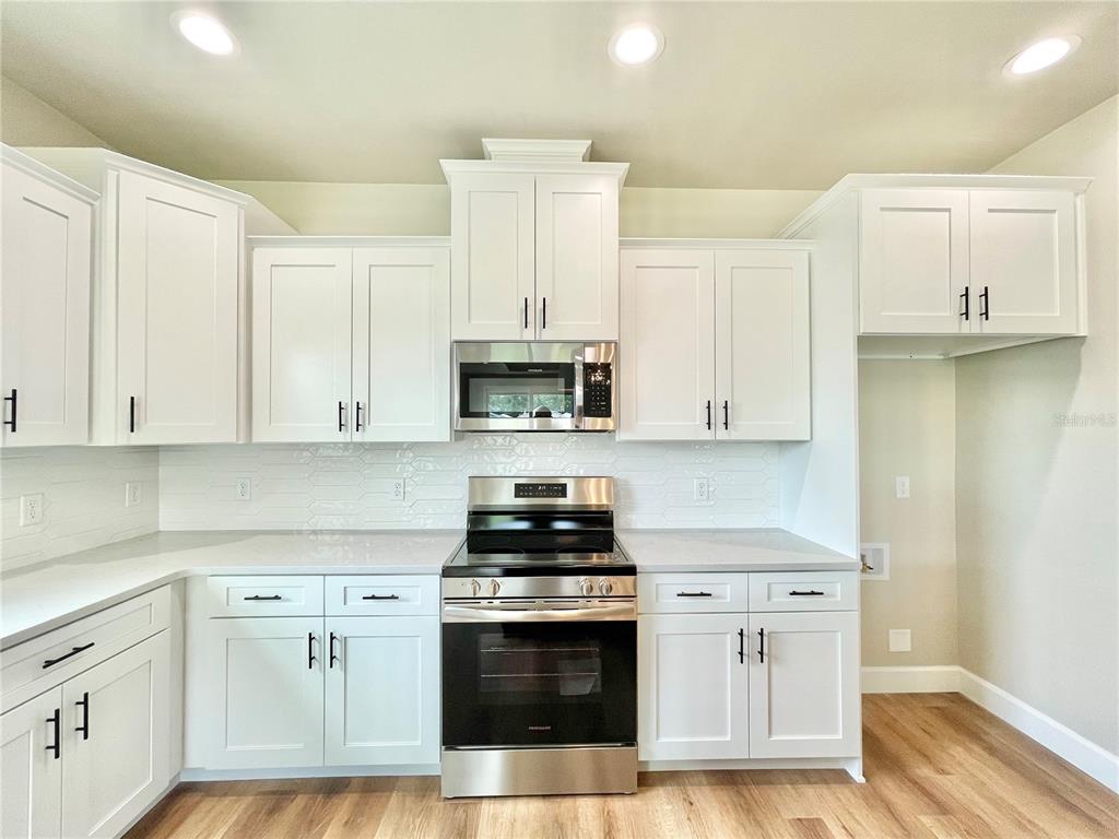 1021 Southwest 67th Street Gainesville, FL 32607 - Photo 3 of 53 a kitchen with stainless steel appliances white cabinets and a stove
