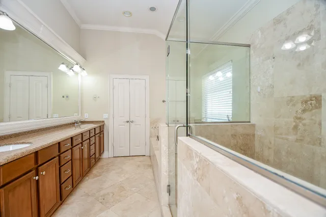 a spacious bathroom with a granite countertop sink mirror bathtub and shower