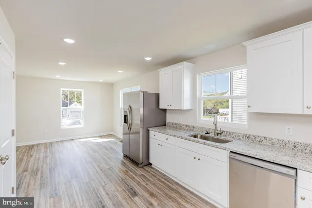 a kitchen with a refrigerator a sink and a stove top oven