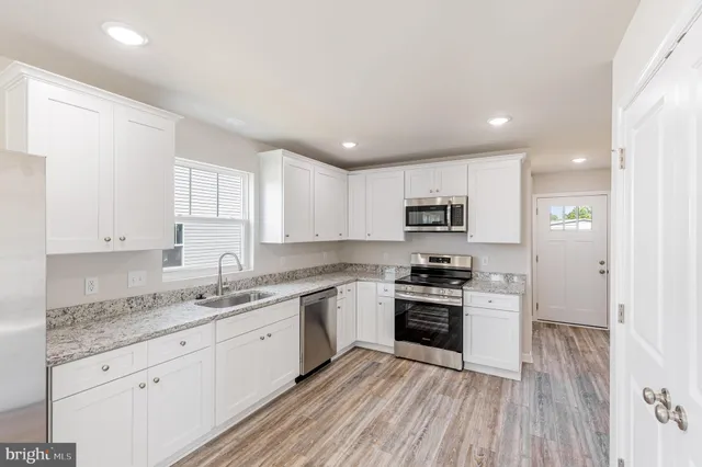 a kitchen with stainless steel appliances granite countertop a stove and a sink