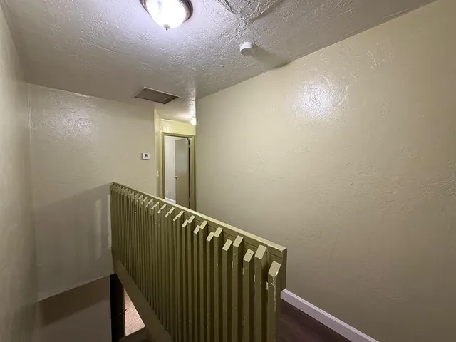 an empty room with a window and ceiling fan